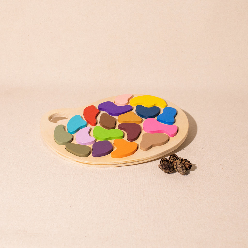 wooden artist palette puzzle with irregular different coloured shapes