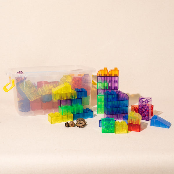 set of transluscent multi-coloured blocks stacked beside plastic carrying case
