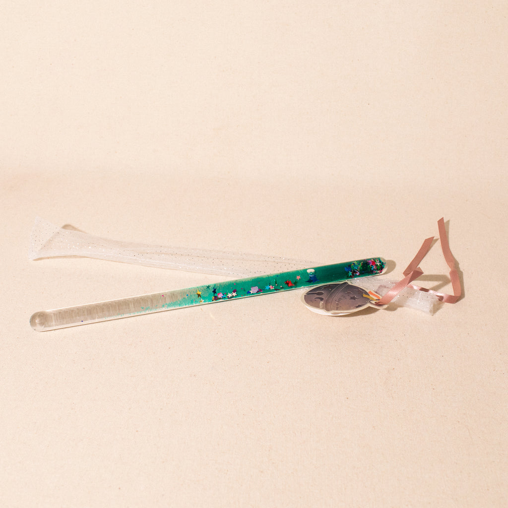 acrylic wand filled with green liquid and sequins