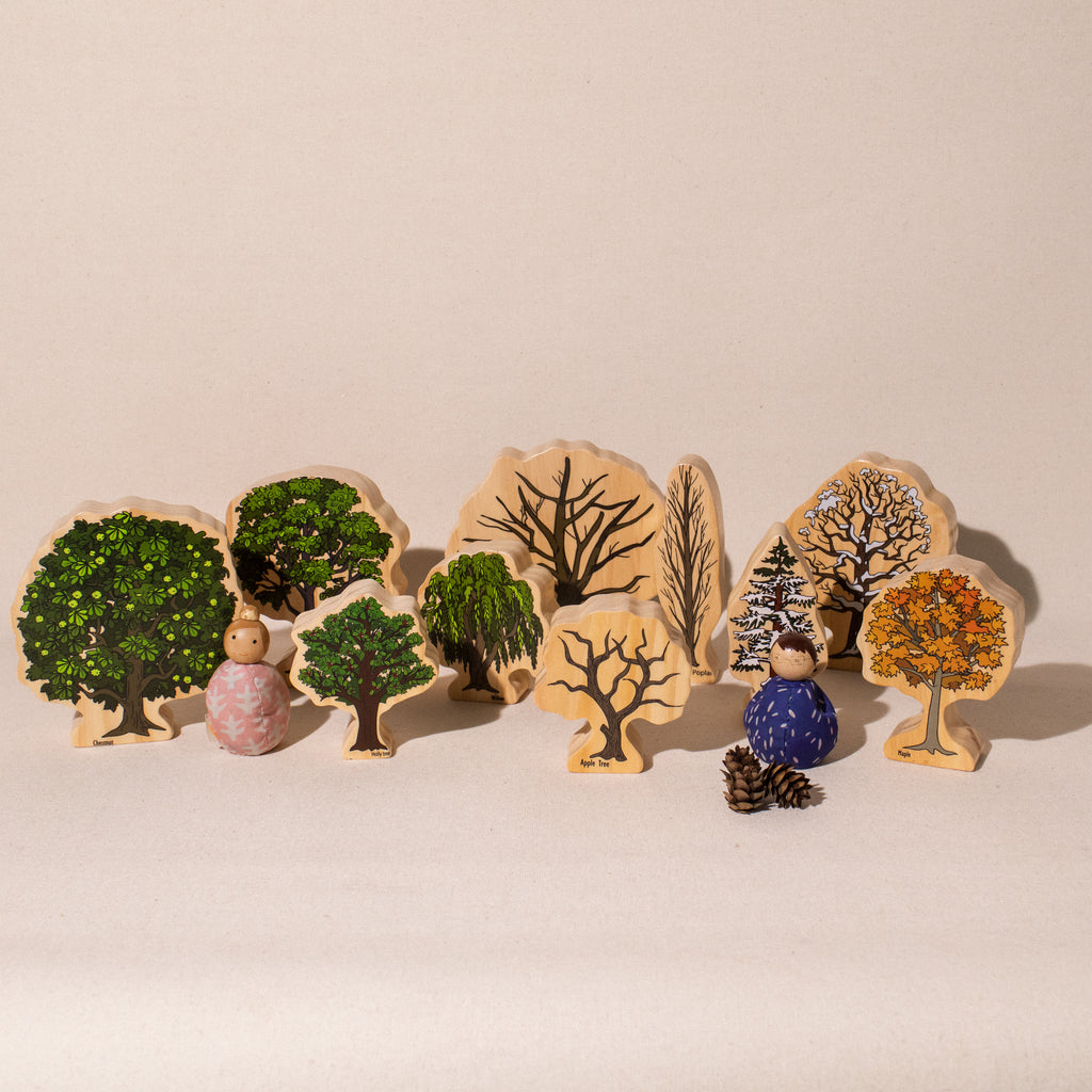 10 freestanding wooden trees showing a mix of spring/summer and fall/winter