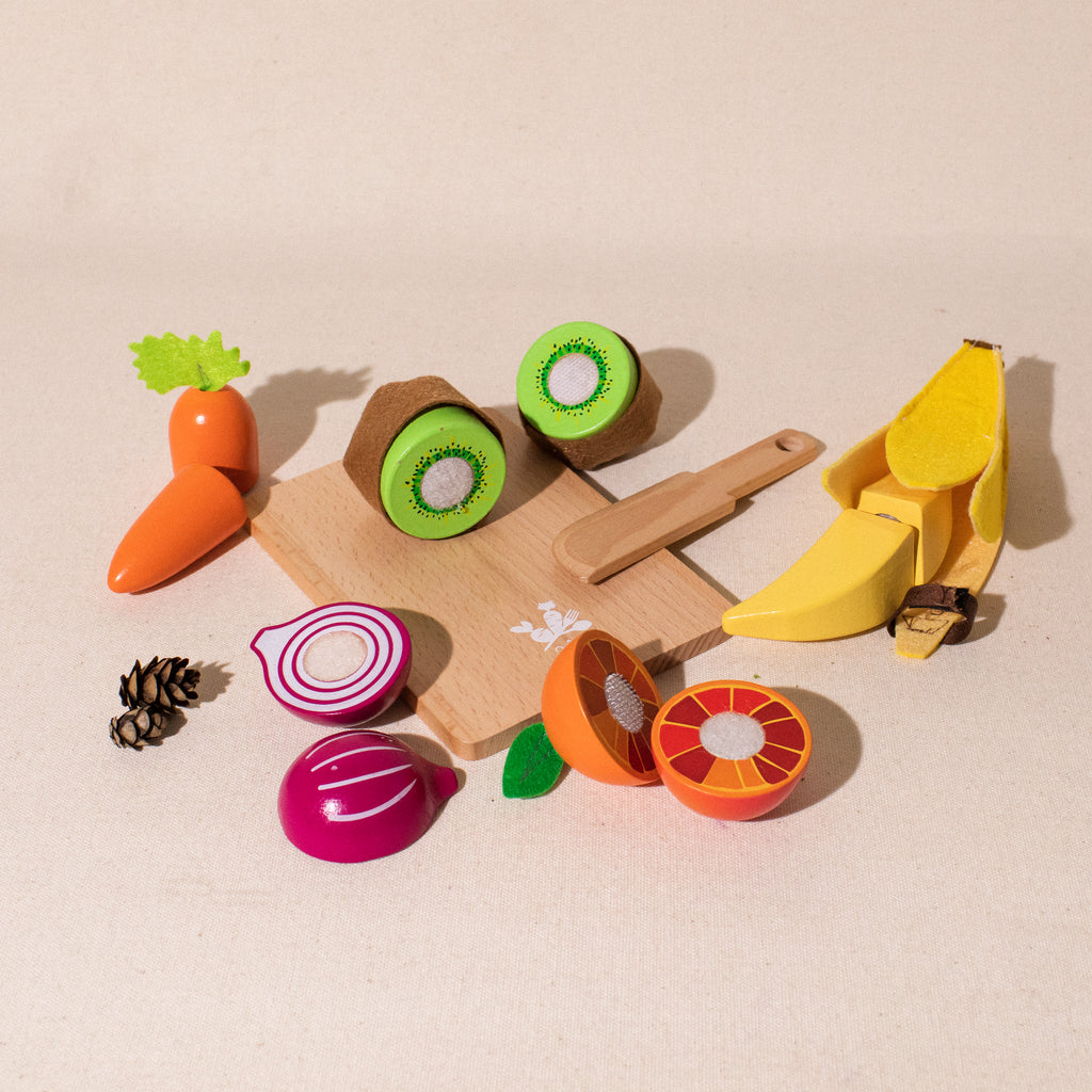 set of wood and fabric fruits and vegetable cut in pieces with cutting board and wooden knife