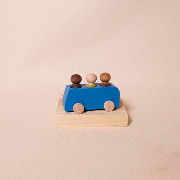 blue wooden bus with 3 people