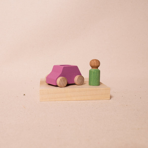 pink wooden car with mint green driver standing beside