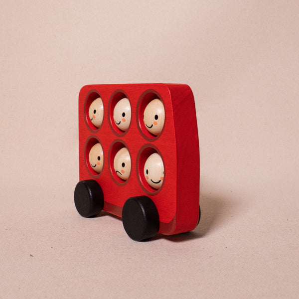 red wooden london bus with happy and sad rotating faces