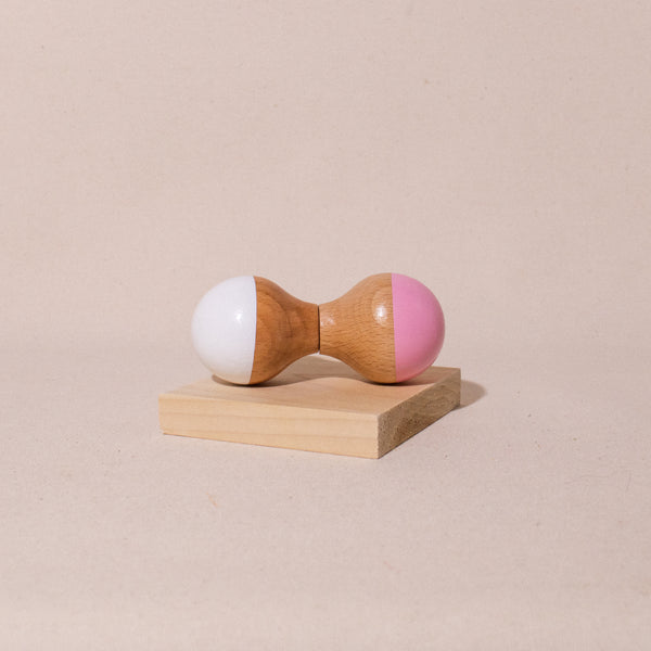 white and pink hourglass shaped wooden maraca rattle