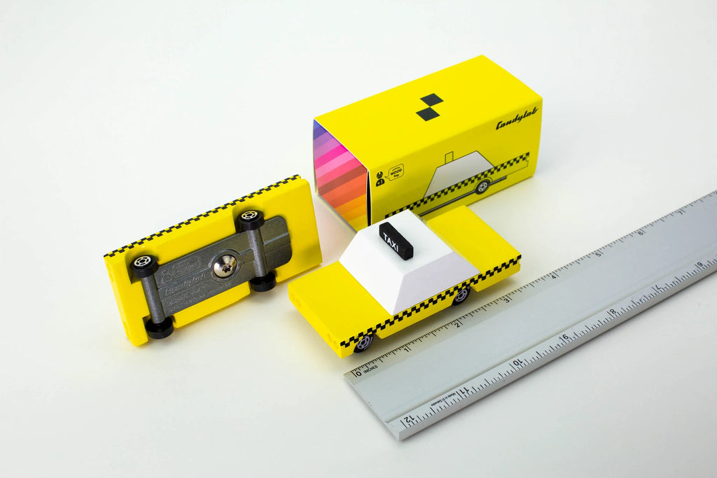 candylab candy car taxi yellow with ruler showing 3 1/2" and another car flipped over to show metal plate on bottom